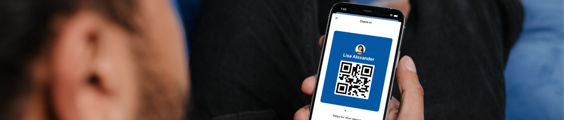 Man reclining on a blue couch, holding a smartphone displaying a digital membership card with a QR code for 'Lisa Alexander' in the Caledon Recreation mobile app