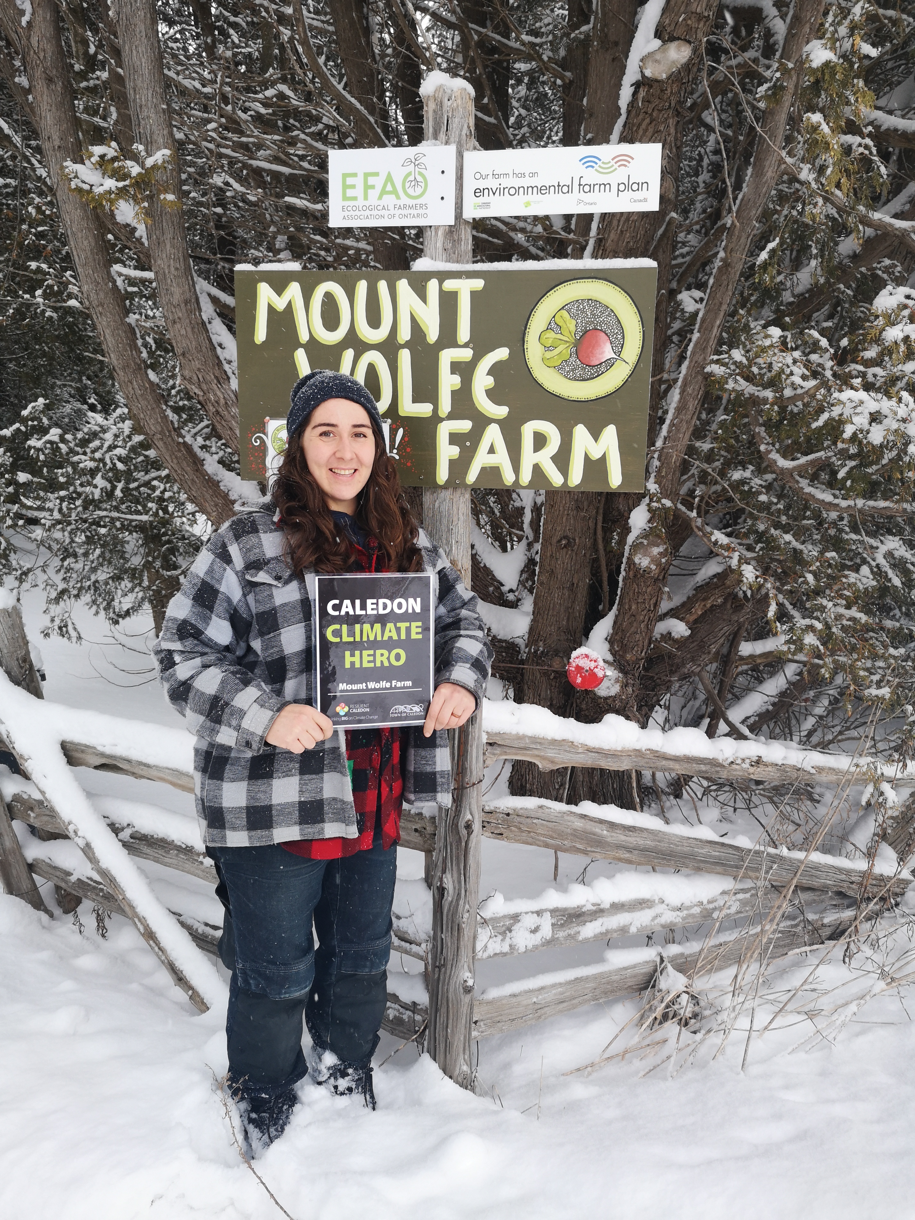 Person standing in from of sign that says Mount Wolfe Farm