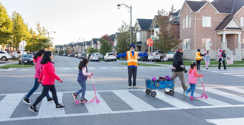 Crossing Guard helping parents and students cross the road.